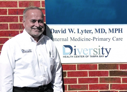 David Lyter stands in front of a wall with his name on it and "Diversity Health Center of Tempa Bay"